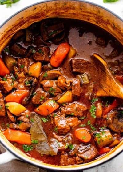 overhead shot of a white dutch oven filled with guinness beef stew.