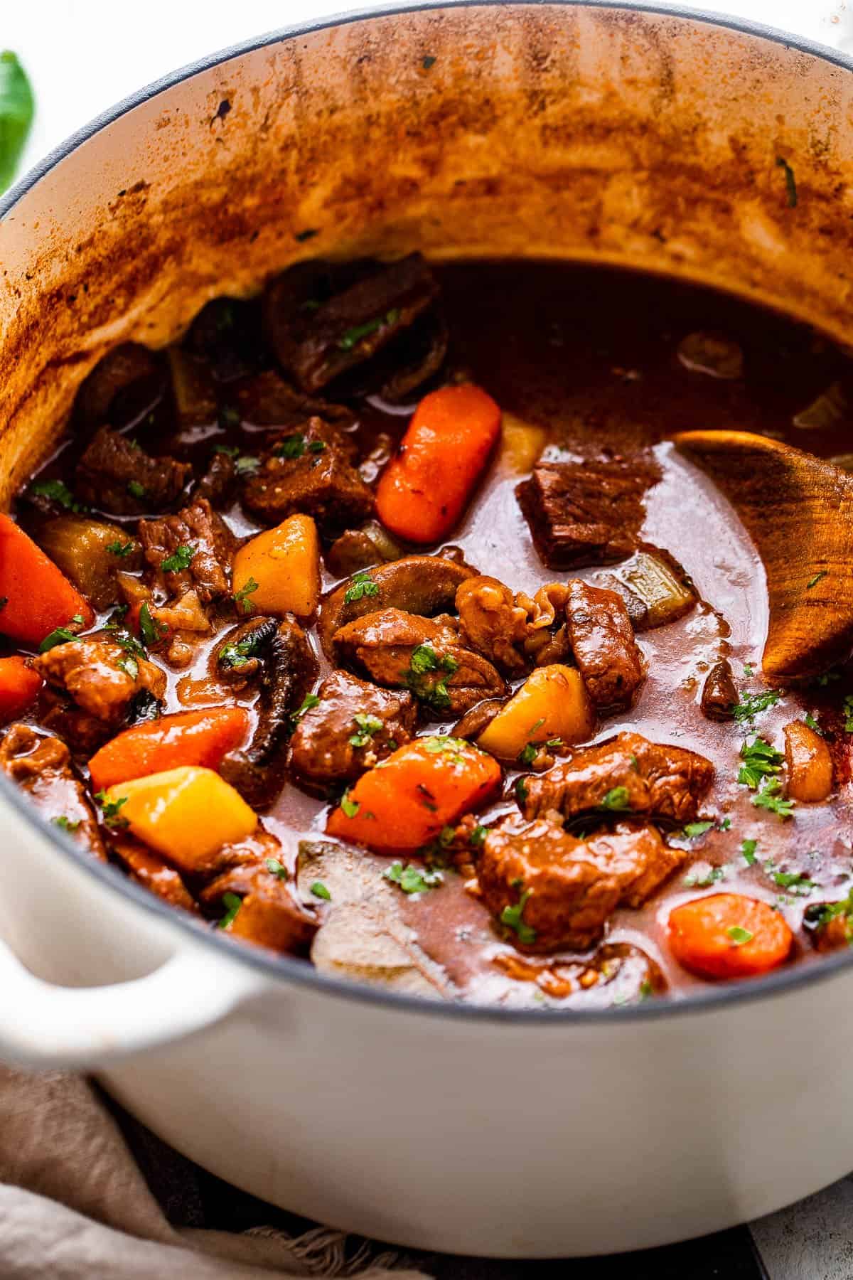 side shot of guinness beef stew studded with chunks of beef and vegetables.