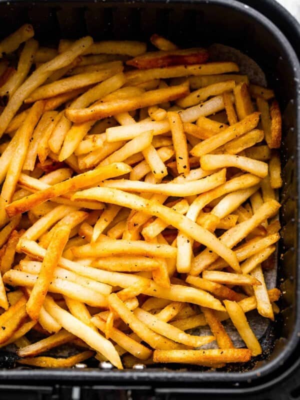 frozen french fries in a black air fryer basket.