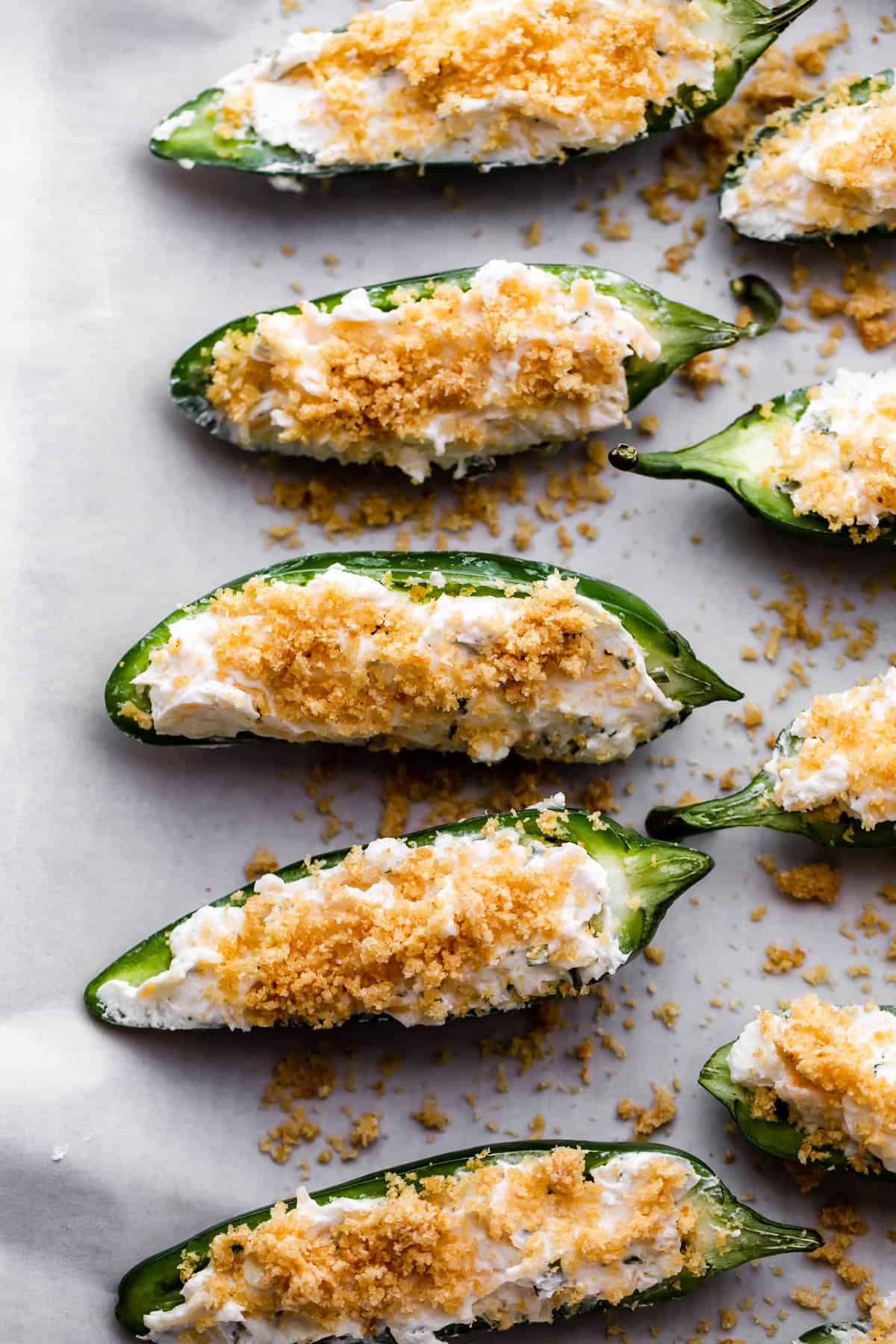 12 halved jalapenos filled with cheese mixture and topped with breadcrumbs.