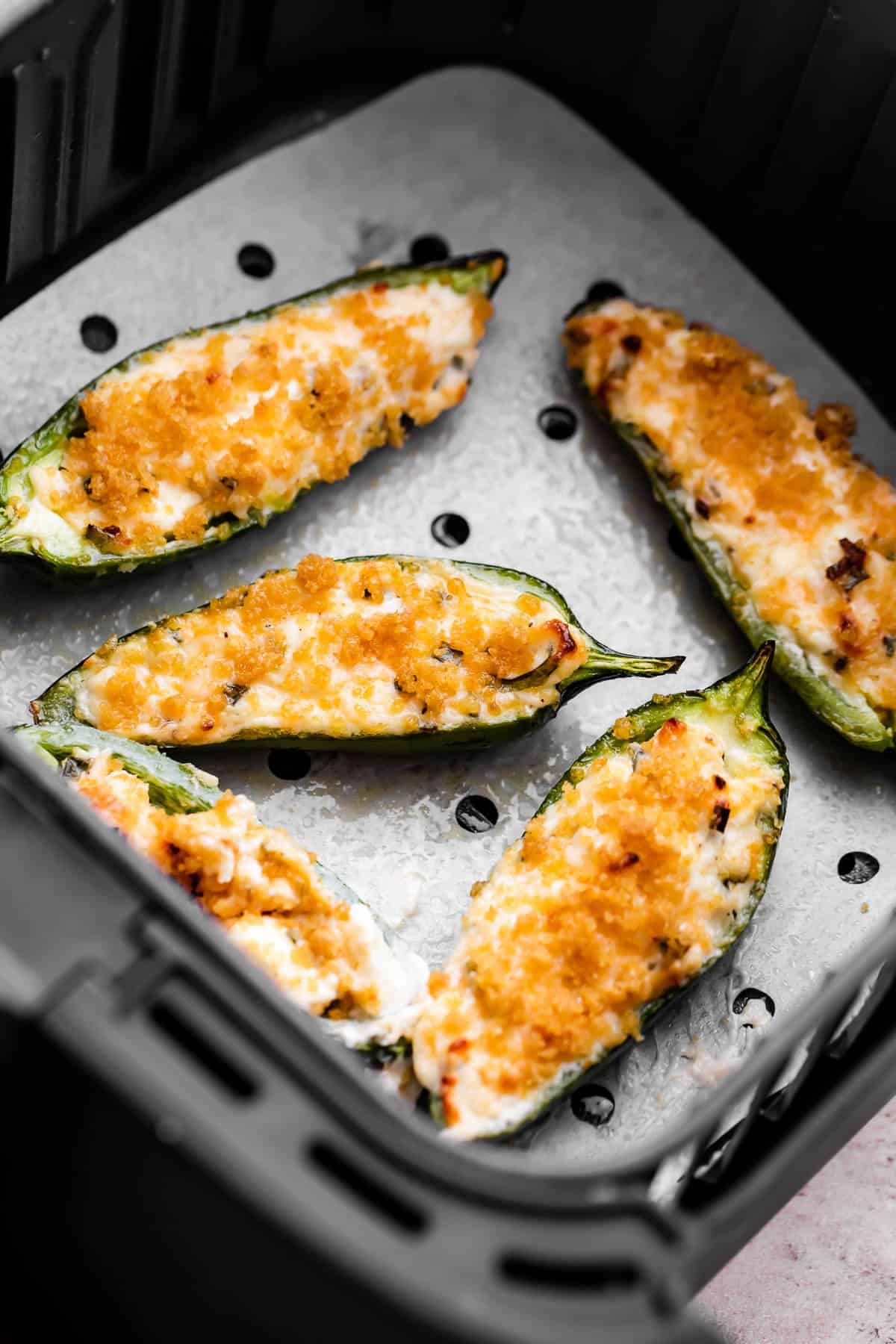 jalapeno poppers in an air fryer basket.