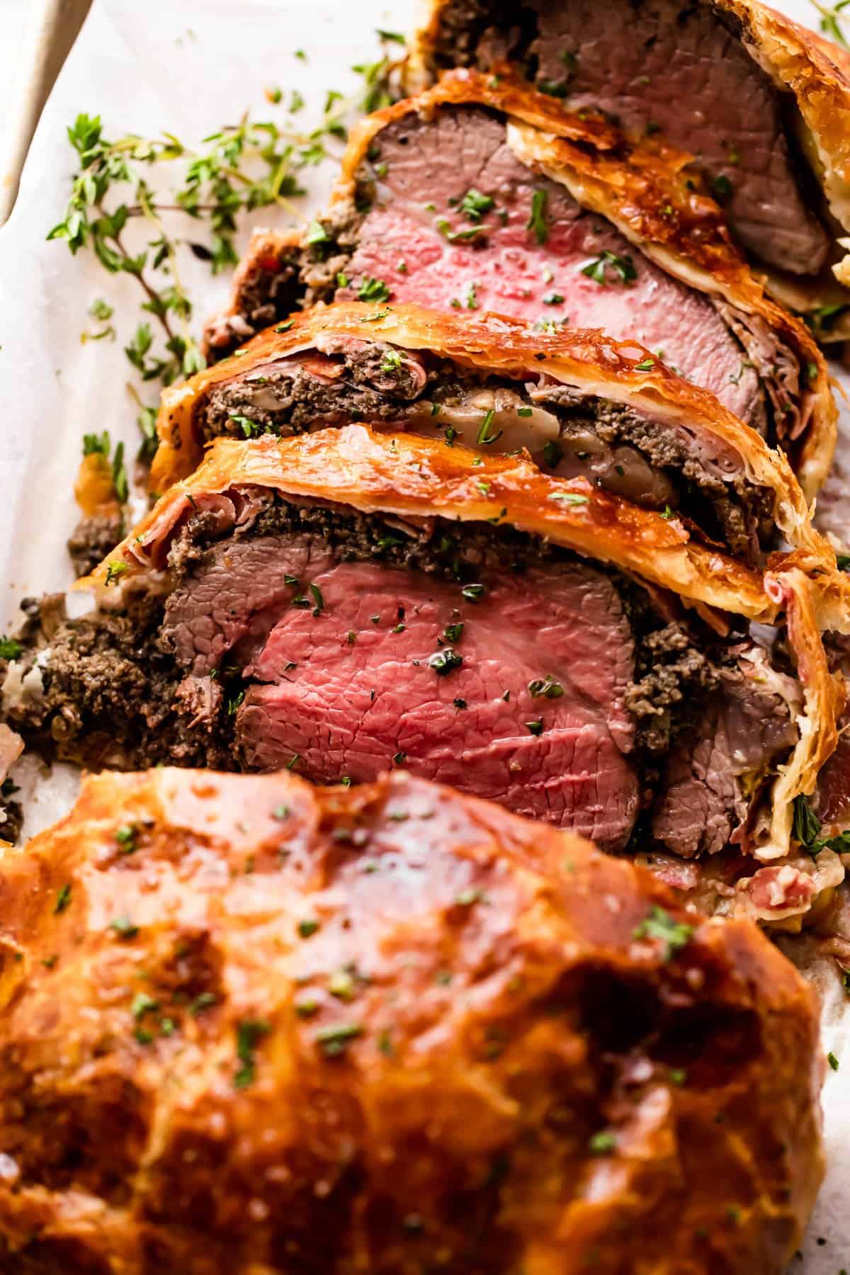 overhead photo of cooked and sliced beef tenderloin wrapped in puff pastry.