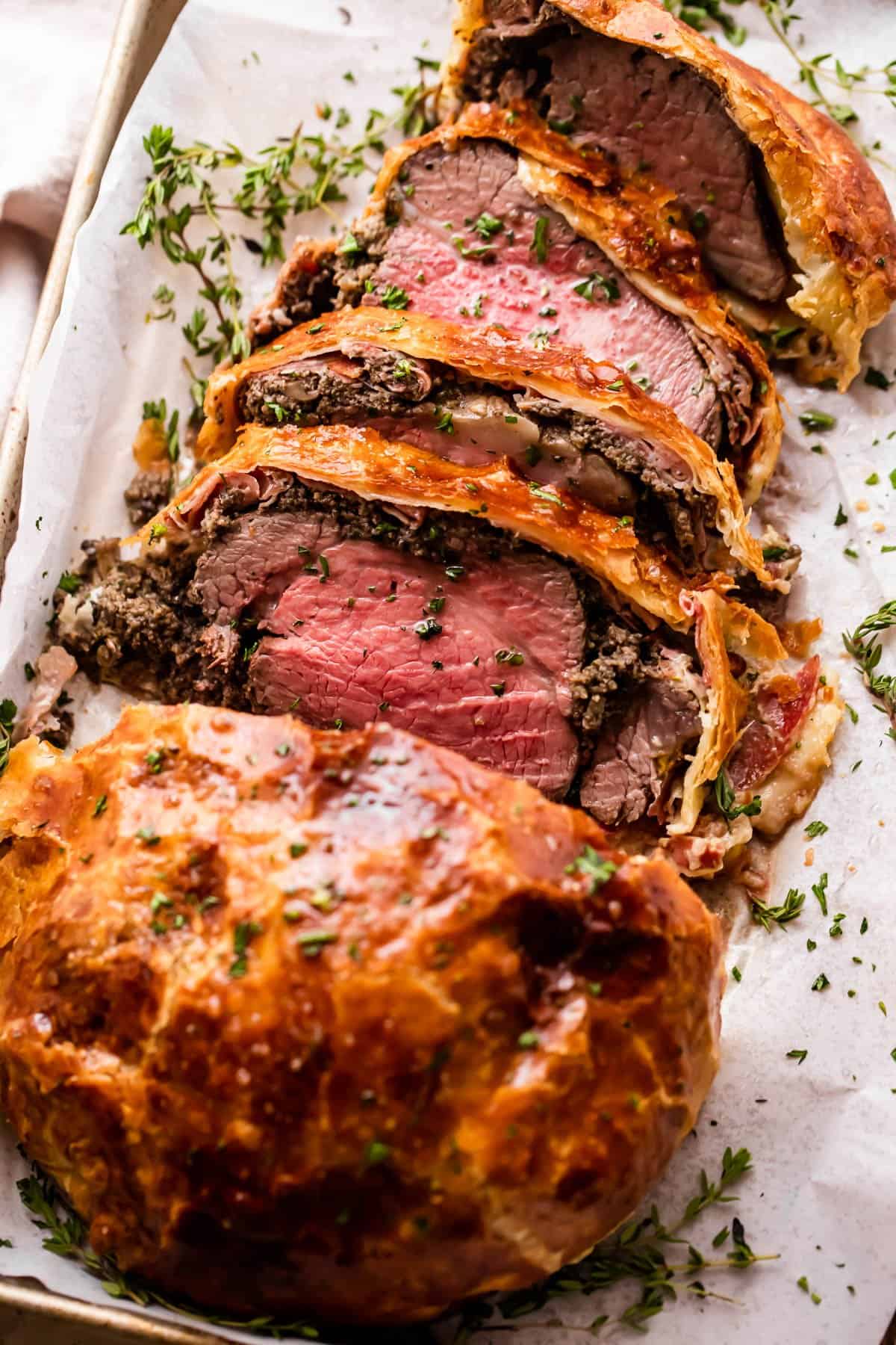 overhead photo of cooked and sliced beef tenderloin wrapped in puff pastry.