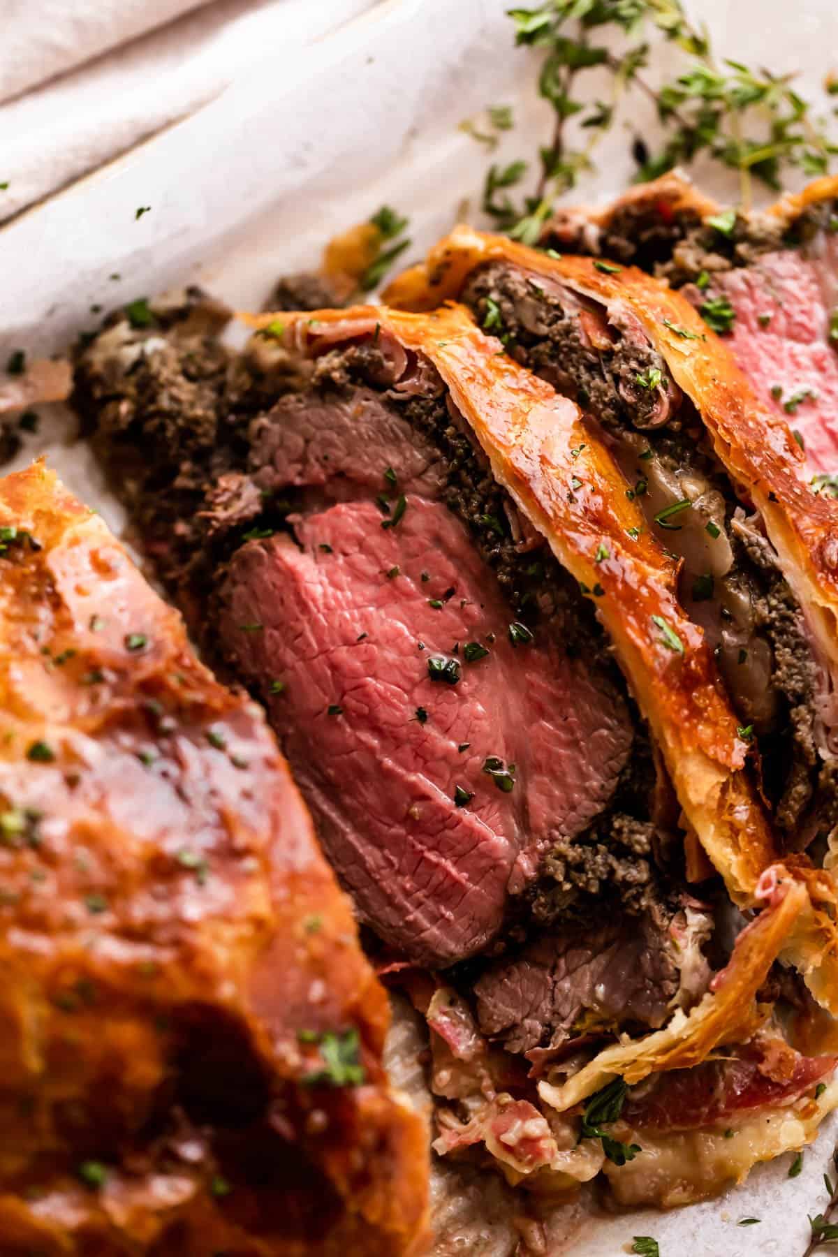 side shot photo of cooked and sliced beef tenderloin wrapped in puff pastry.