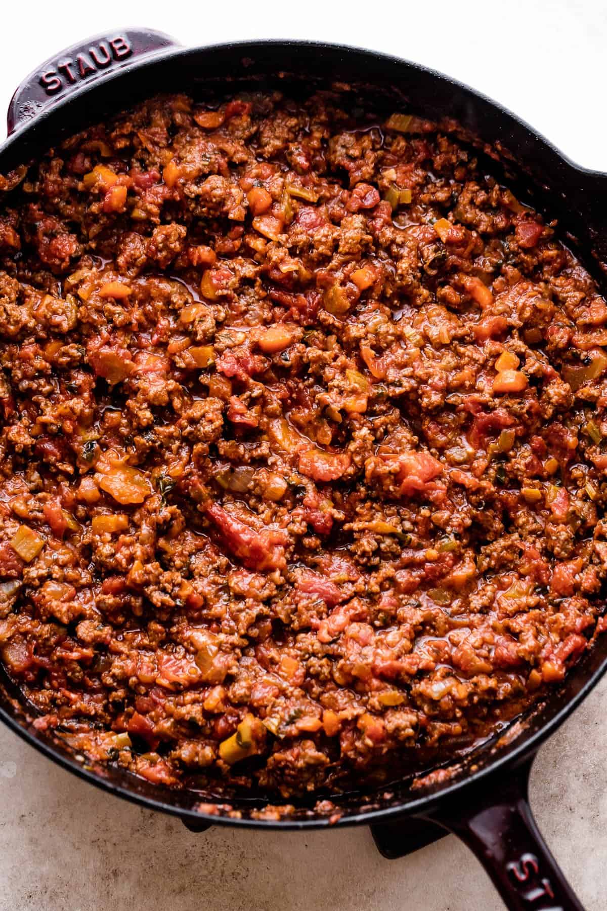 cooking Homemade Bolognese Sauce in a dark cast iron skillet