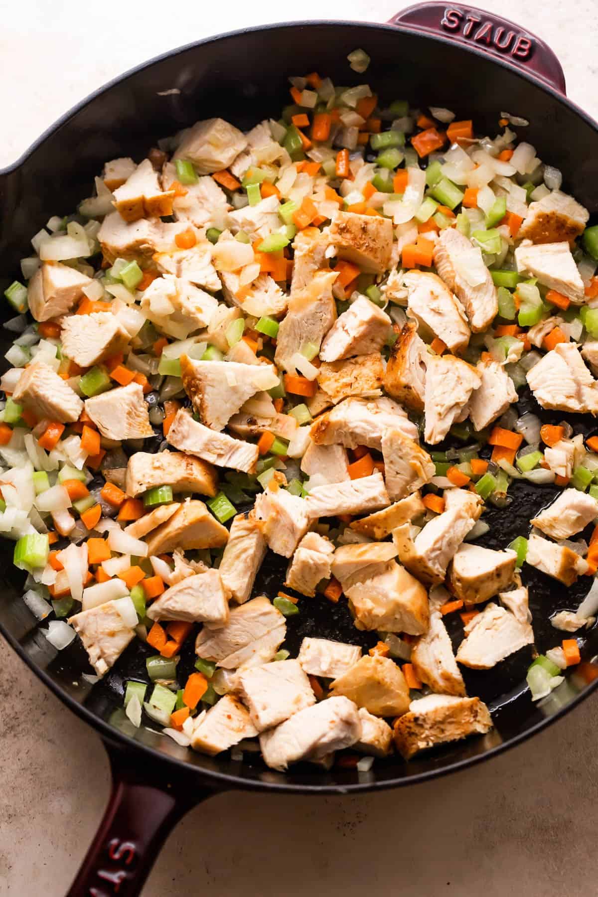 a skillet with sauteed diced veggies and cooked turkey chunks.