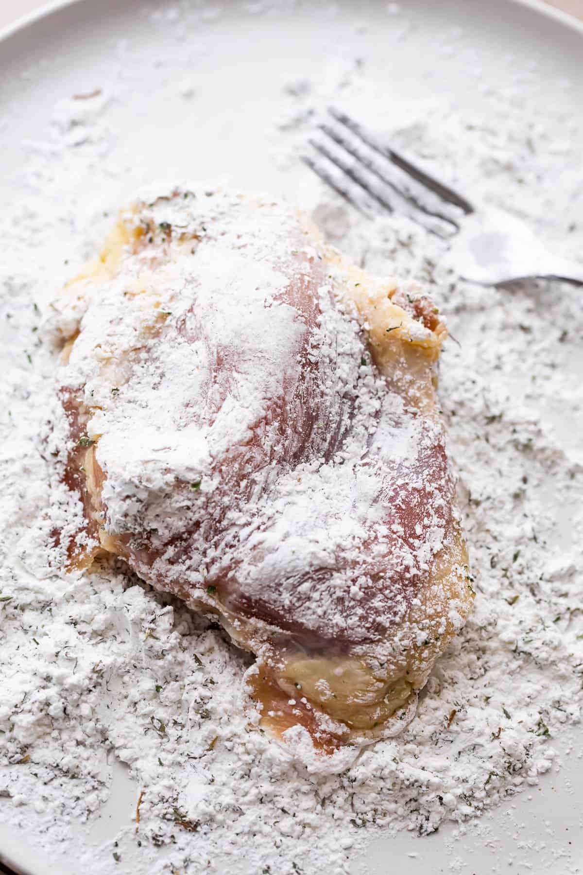 dredging chicken thighs in flour.