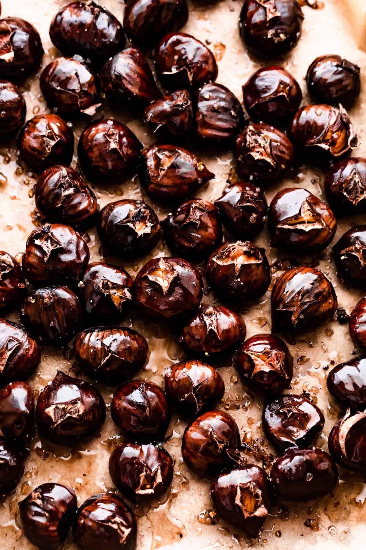 roasted chestnuts arranged on a baking sheet.
