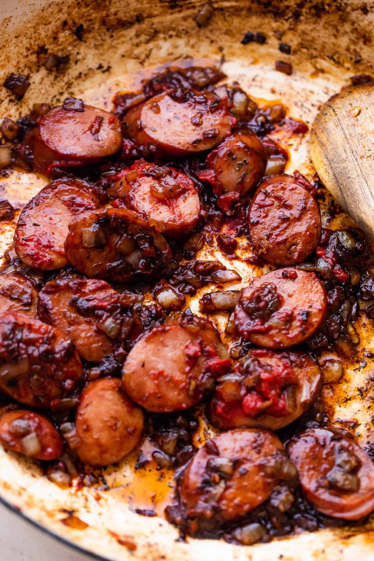 browning sliced smoked sausages in a skillet.