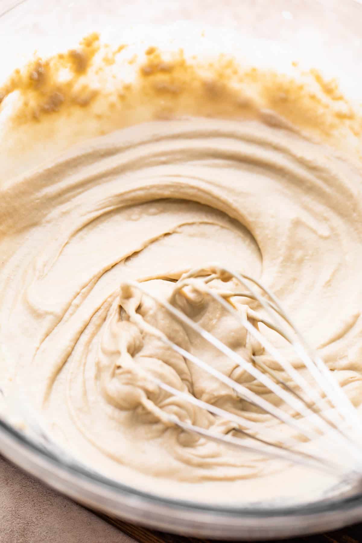 whisking tahini sauce in a bowl.