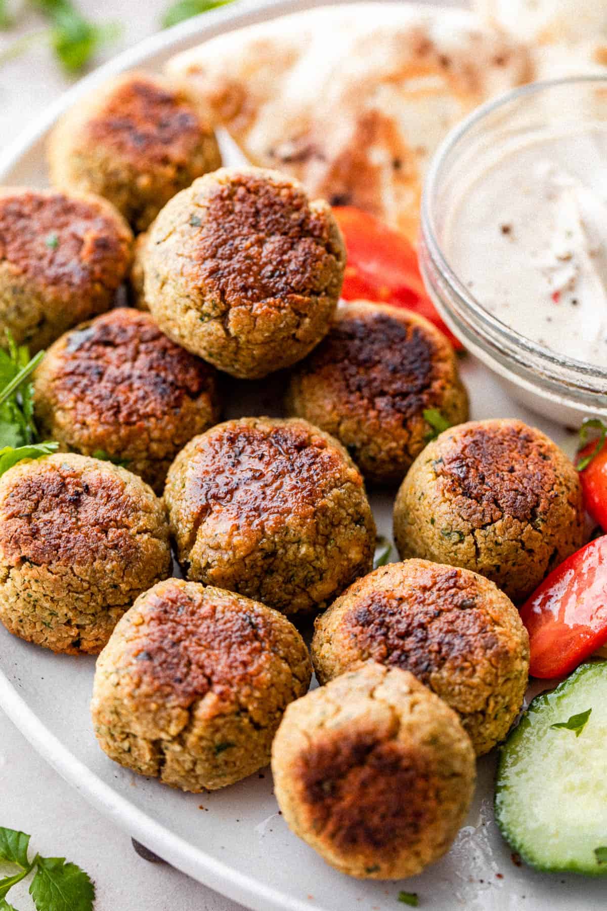 baked falafel arranged on a white plate.