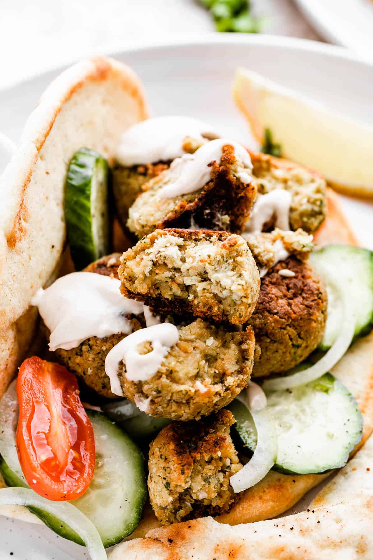 pita bread stuffed with cucumber slices, cherry tomatoes, and falafel