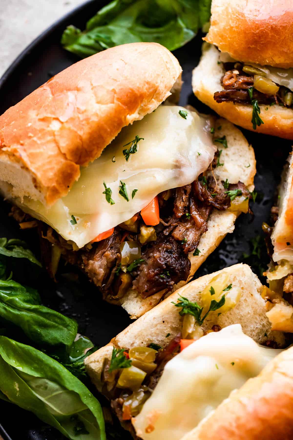 Slow Cooker Italian Beef Sandwiches arranged on a black plate.