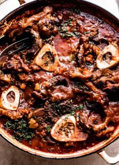 four bone in beef shanks cooked in a braiser with tomato sauce.