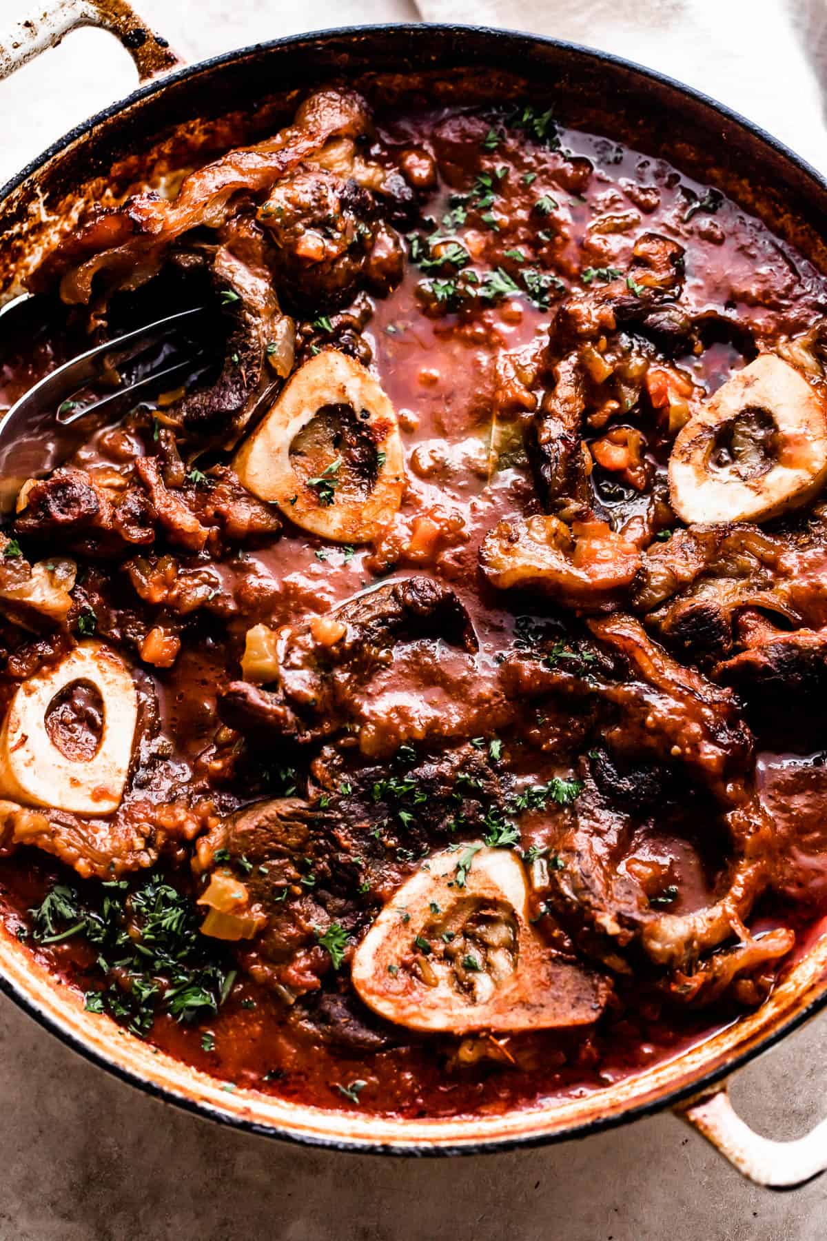 four bone in beef shanks cooked in a braiser with tomato sauce.