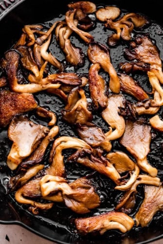 up close photo of cooking oyster mushrooms in a heavy skillet