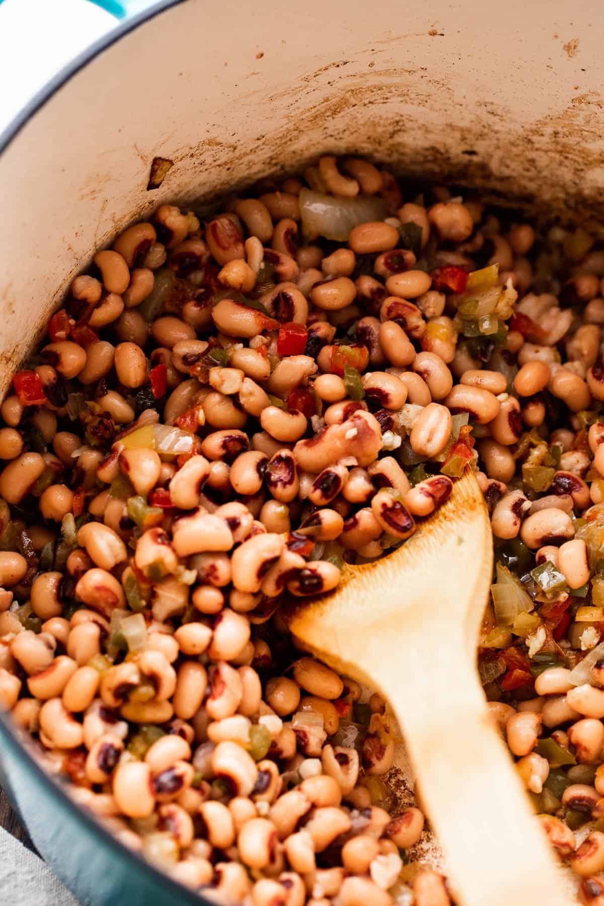 cooking black eyed peas in a dutch oven and stirring through with a wooden spoon.