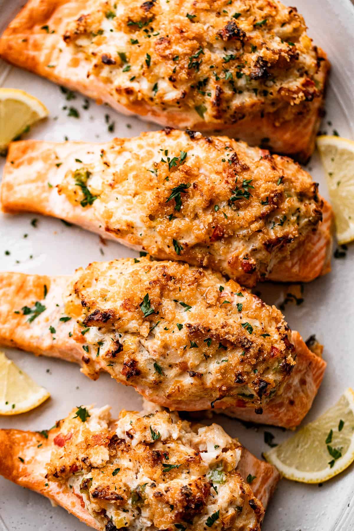 Overhead shot of four stuffed salmon fillets arranged on a long oval plate.