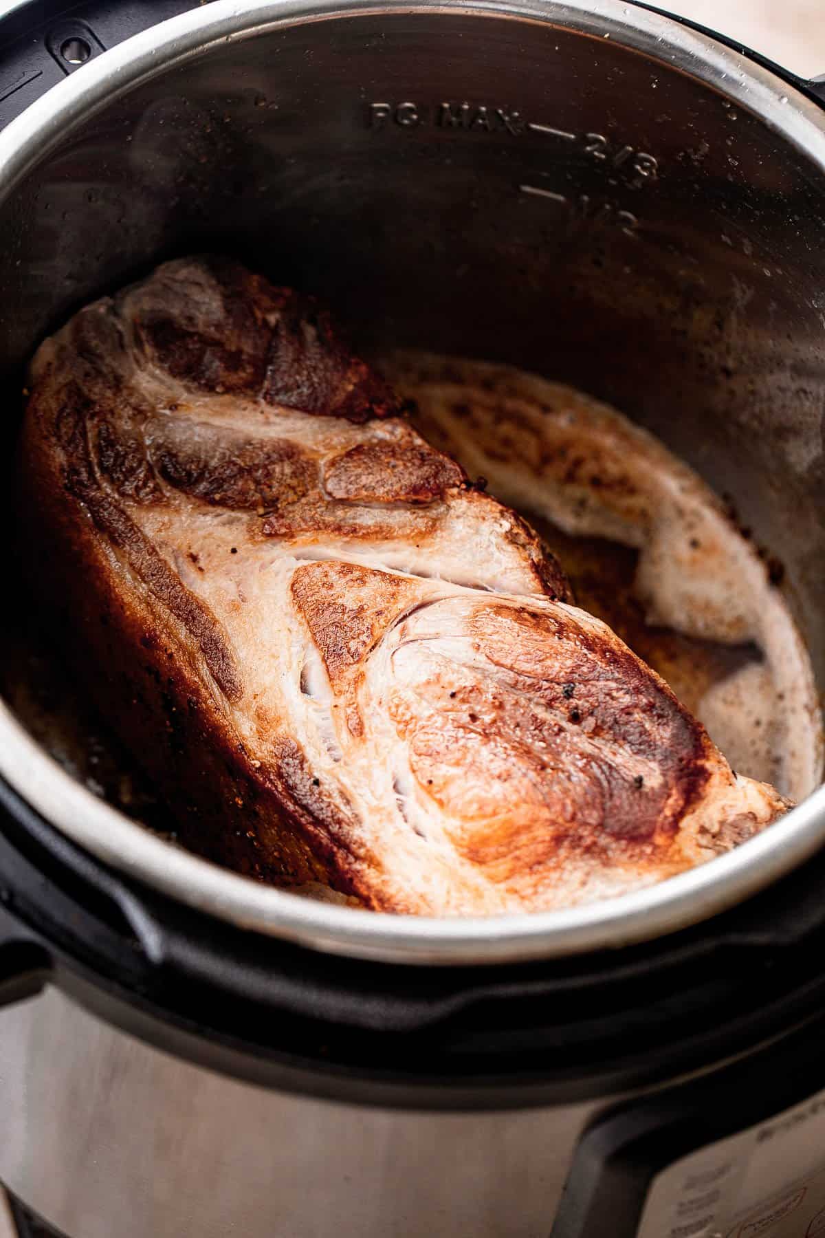Browning a piece of pork inside the Instant Pot.