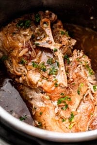 close up shot of a cooked pork shoulder garnished with parsley.