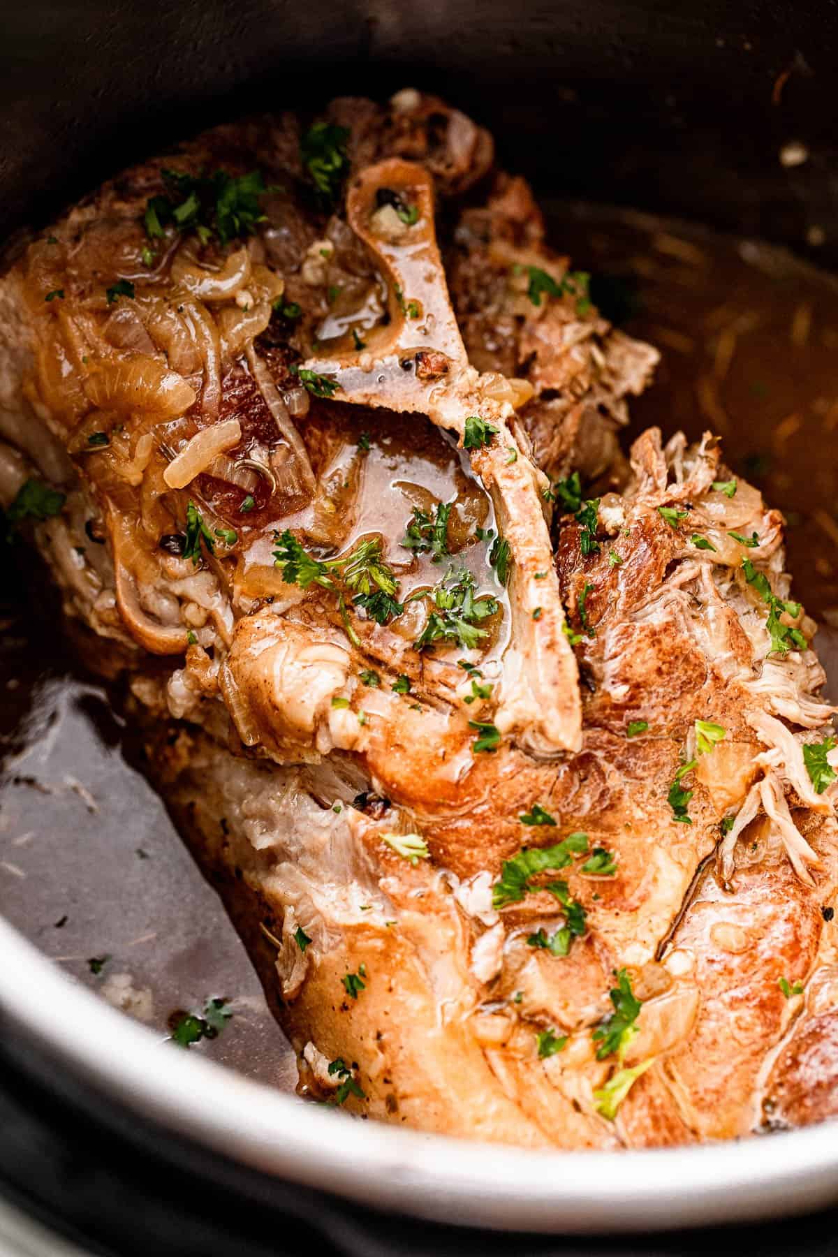 Close-up shot of a cooked pork shoulder garnished with parsley.