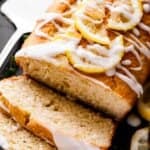 side shot of a lemon yogurt cake with two slices cut from one end of it.