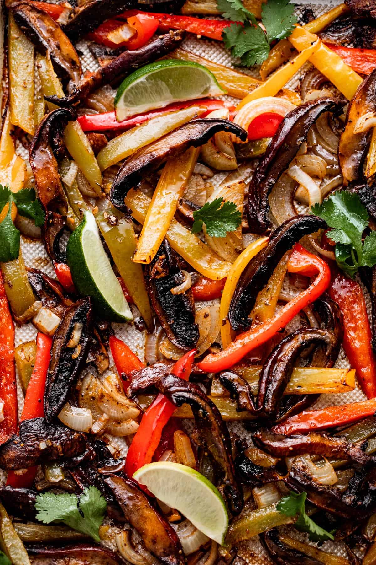 up close shot of sliced portobello mushrooms, sliced bell peppers, and sliced onions inside a glass bowl