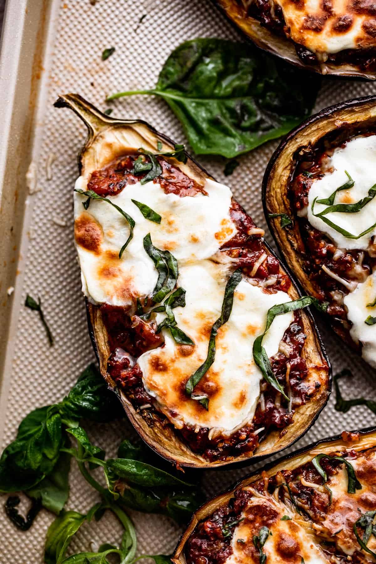 overhead shot of Tomato Parmesan Stuffed Eggplant topped with melted fresh mozzarella cheese and chopped basil.
