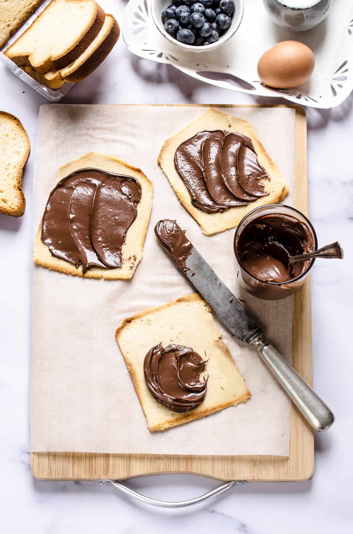 Three flattened pieces of bread with chocolate hazelnut spread on each one