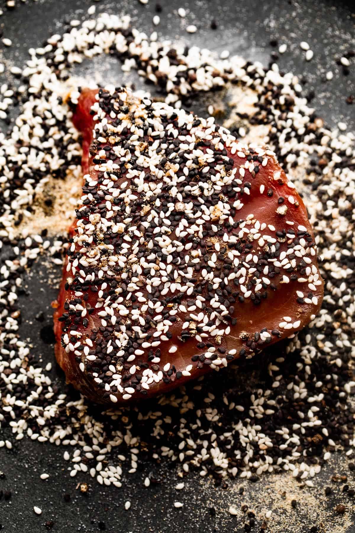 raw tuna steak topped with black and white sesame seeds.