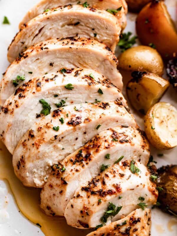 close up photo of slow cooker chicken breast, sliced and arranged on a white dinner plate.