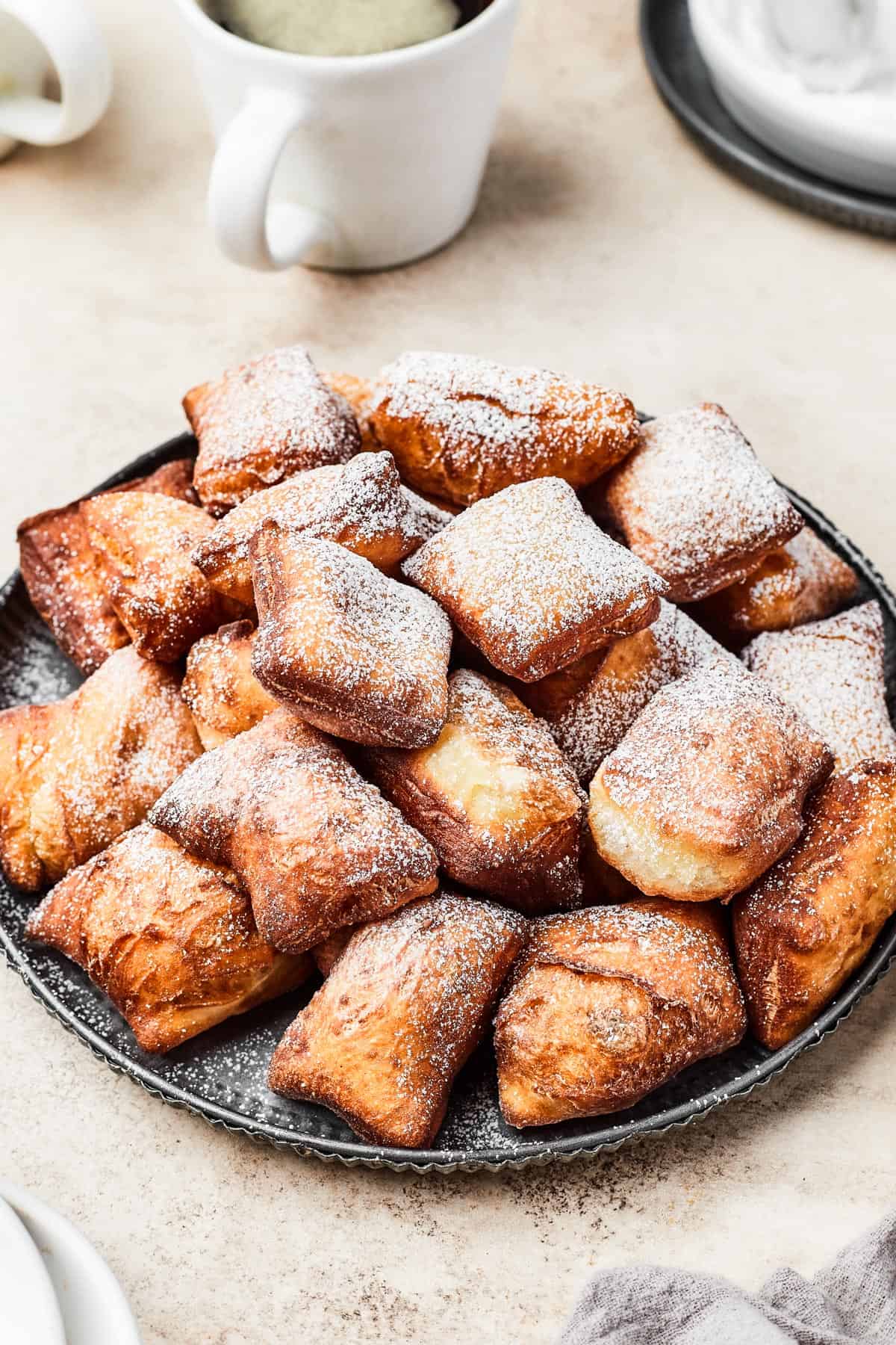 New Orleans-style Beignets stacked and served on a plate.