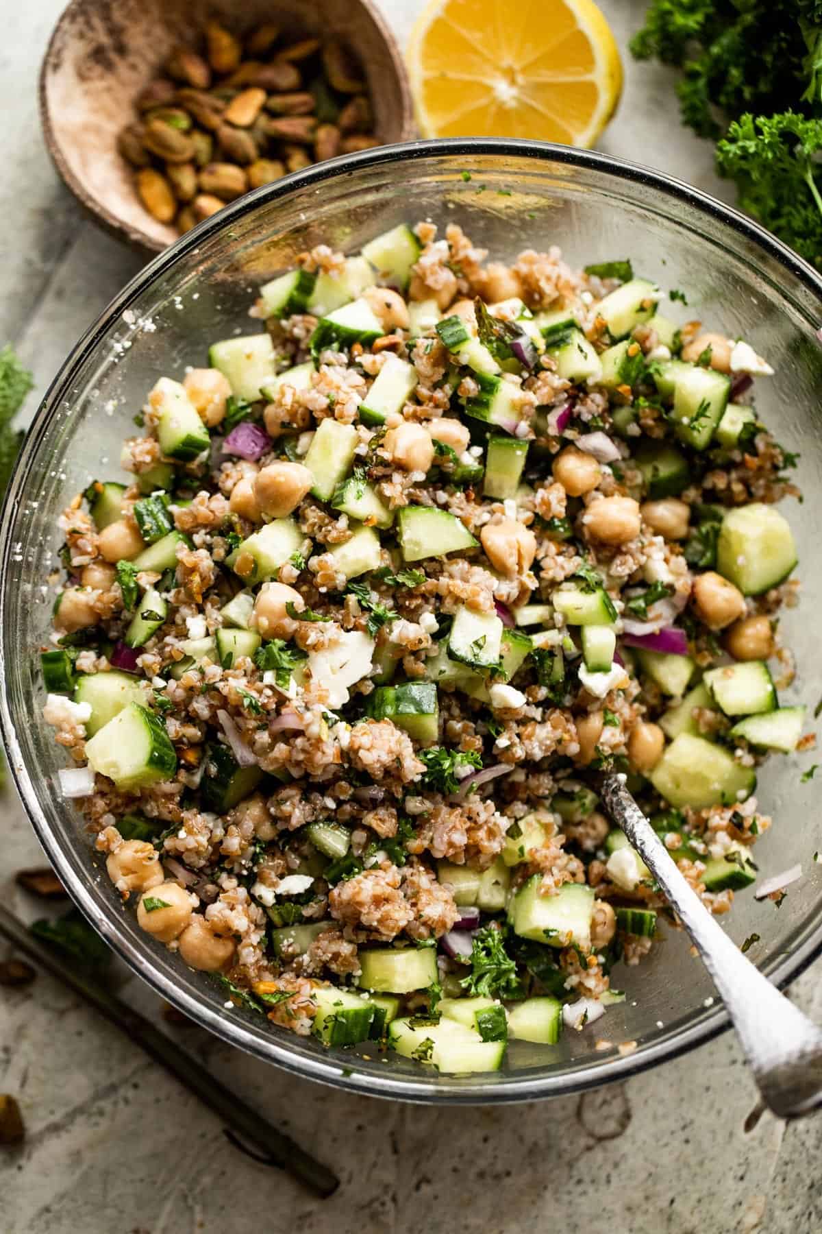 Overhead shot of a glass mixing bowl with bulgur salad.