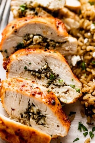 up close shot of an air fried chicken breast cut into slices and served alongside wild rice.