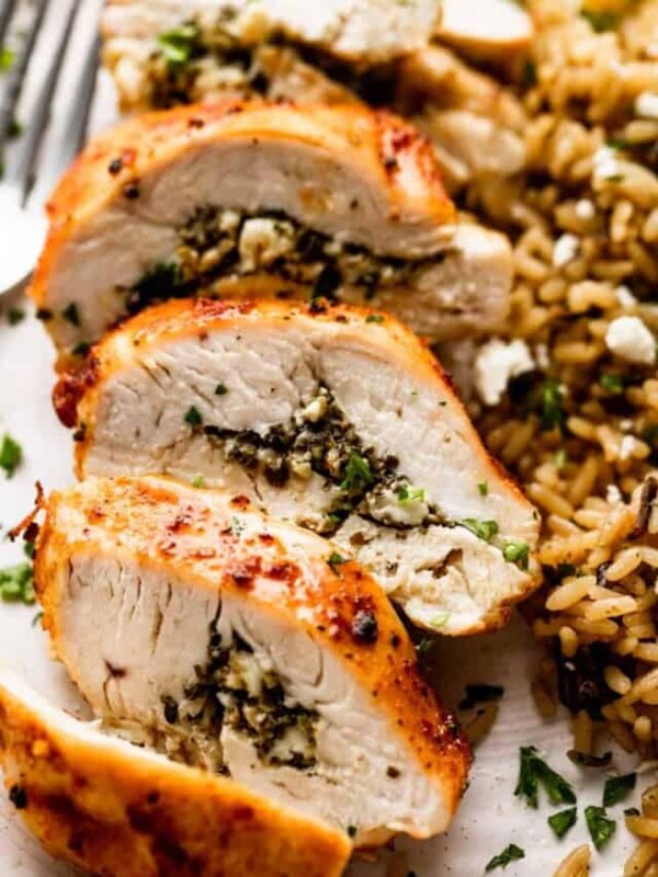 up close shot of an air fried chicken breast cut into slices and served alongside wild rice.