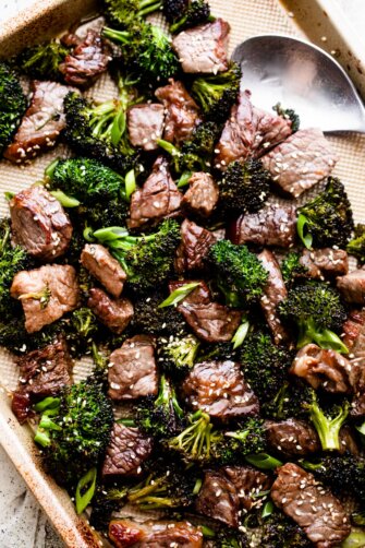overhead shot of sesame beef and broccoli arranged on a baking sheet.
