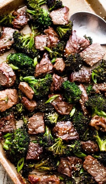 overhead shot of sesame beef and broccoli arranged on a baking sheet.