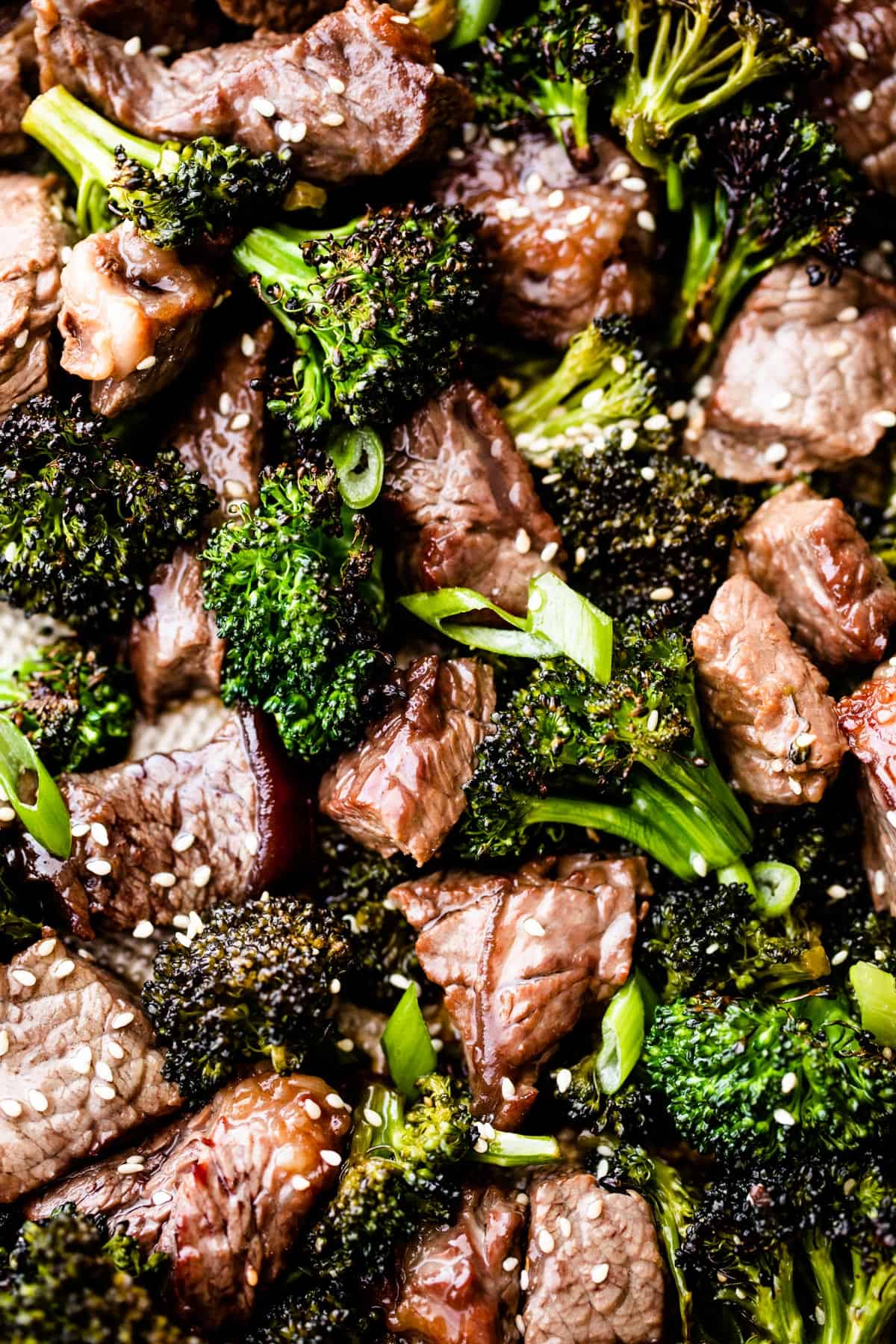 close up shot of roasted sesame beef and broccoli arranged on a baking sheet.