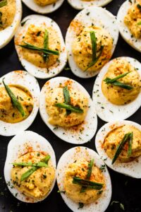 close up overhead shot of deviled eggs set on a dark backdrop.