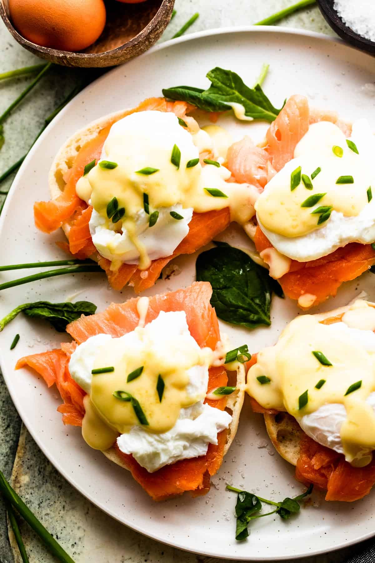 overhead shot of eggs halifax arranged on a white serving plate, and garnished with hollandaise sauce and fresh chives.