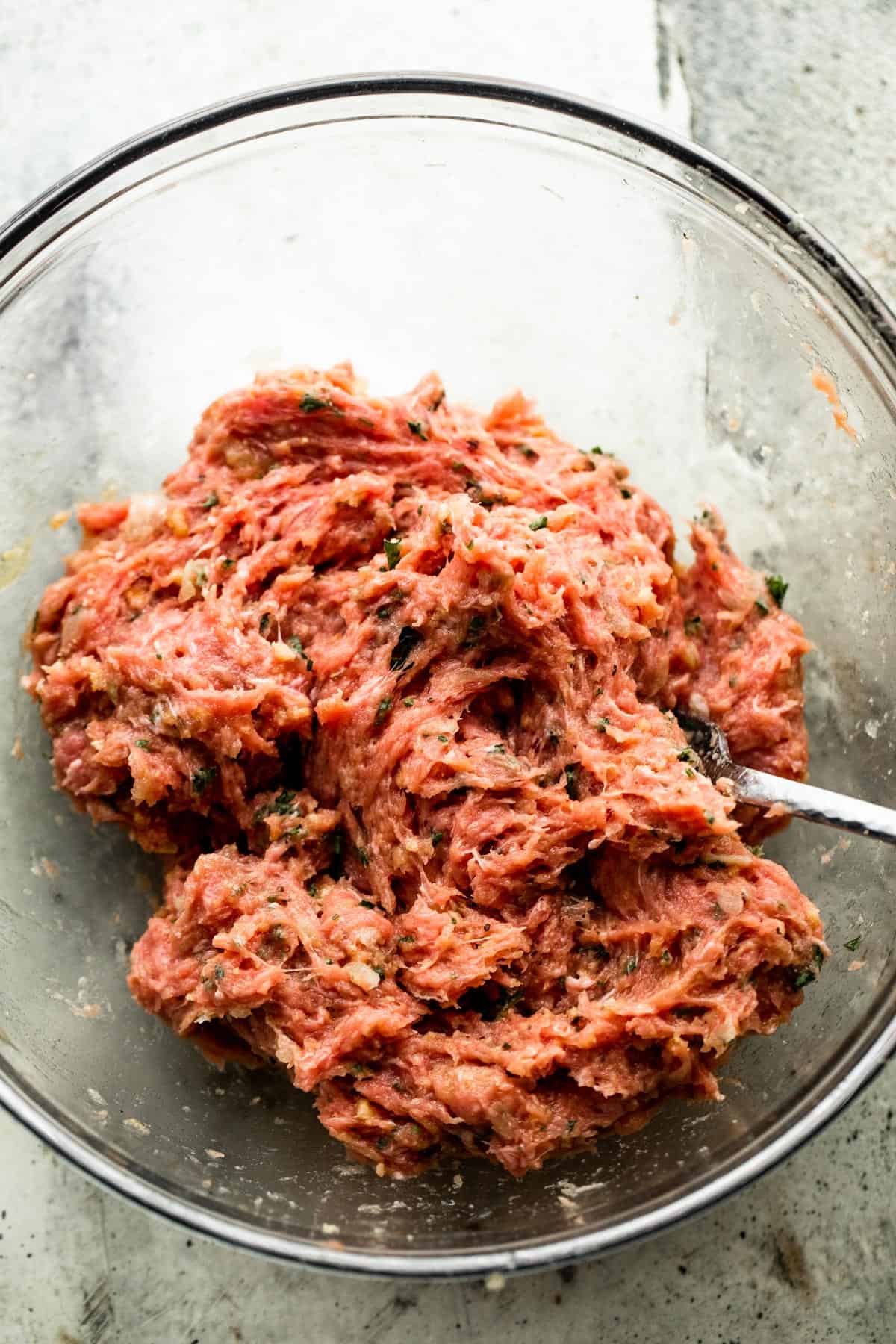 With just a few simple ingredients, these Juicy Grilled Turkey Burgers are guaranteed to turn out savory, tender, and perfect, every time! ground turkey meat in a glass mixing bowl.