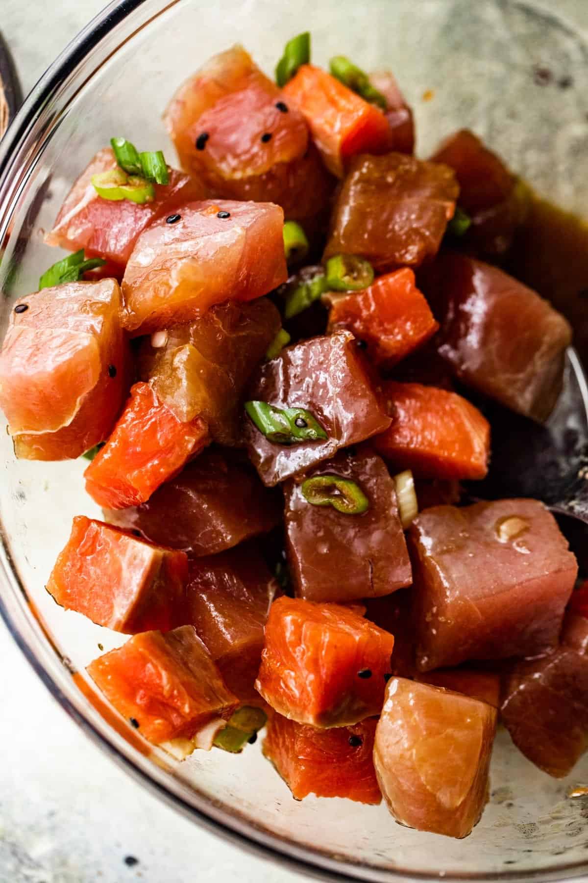 diced raw tuna and salmon in a glass bowl.