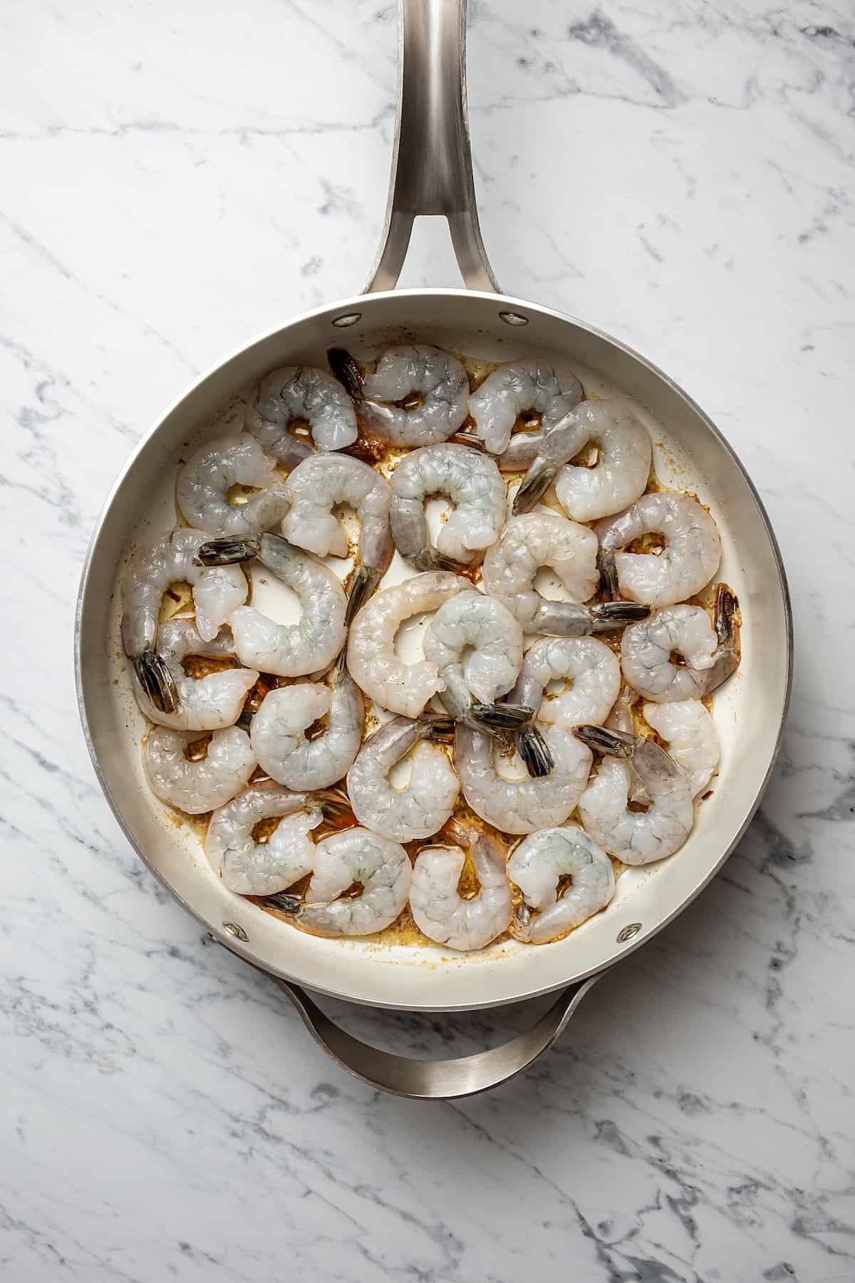 Raw shrimp in a skillet ready to be cooked