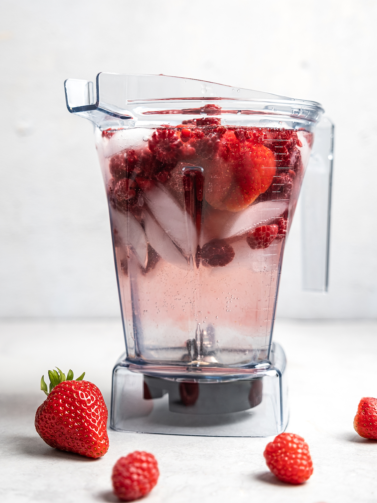Berries, ice, white claw and captain morgan in a blender.