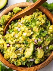 An overhead shot of salsa verde being stirred by a wooden spoon