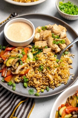 A plate with Hibachi chicken fried rice and veggies