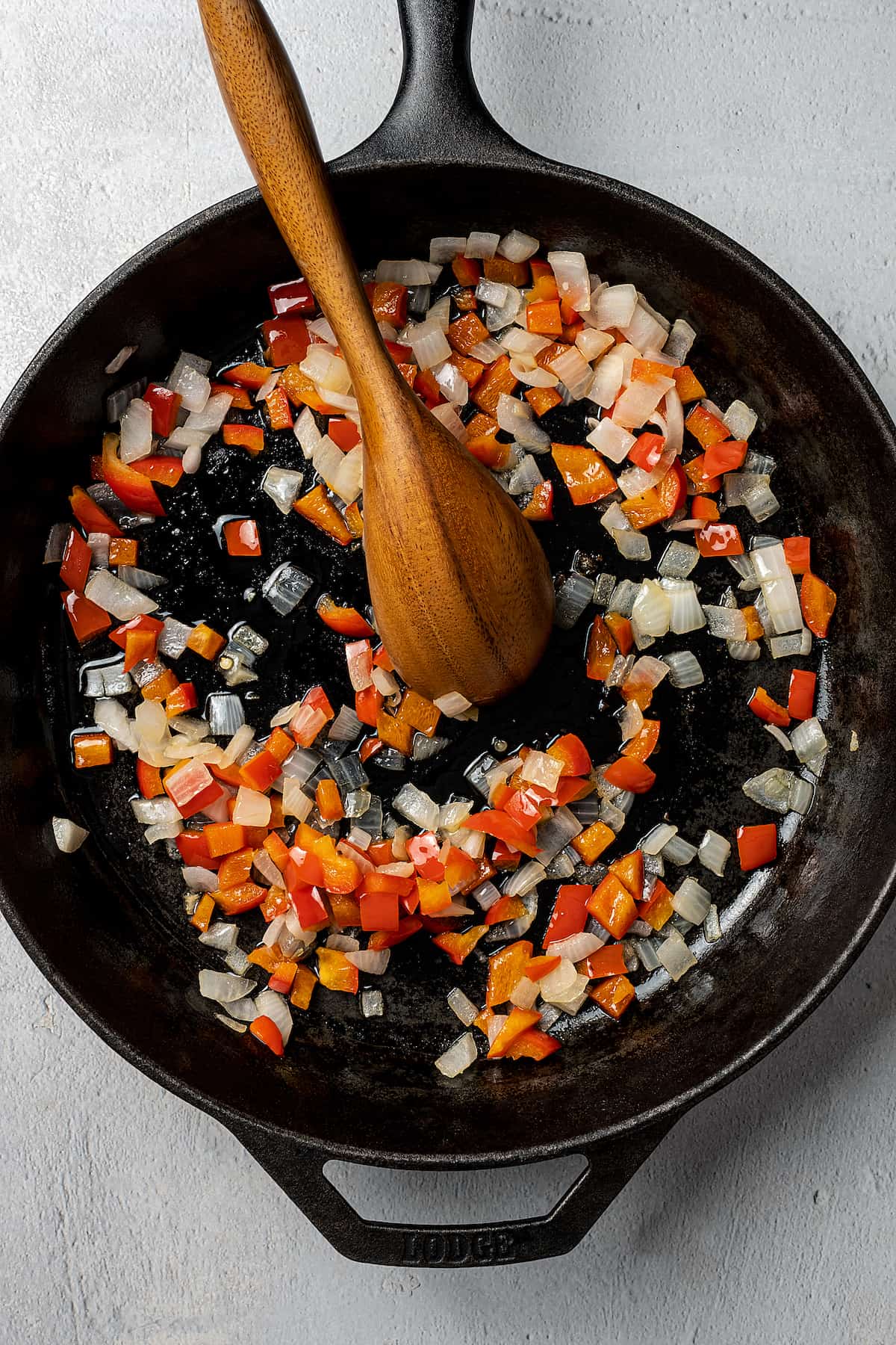 Chopped vegetables cooking in a cast-iron skillet.