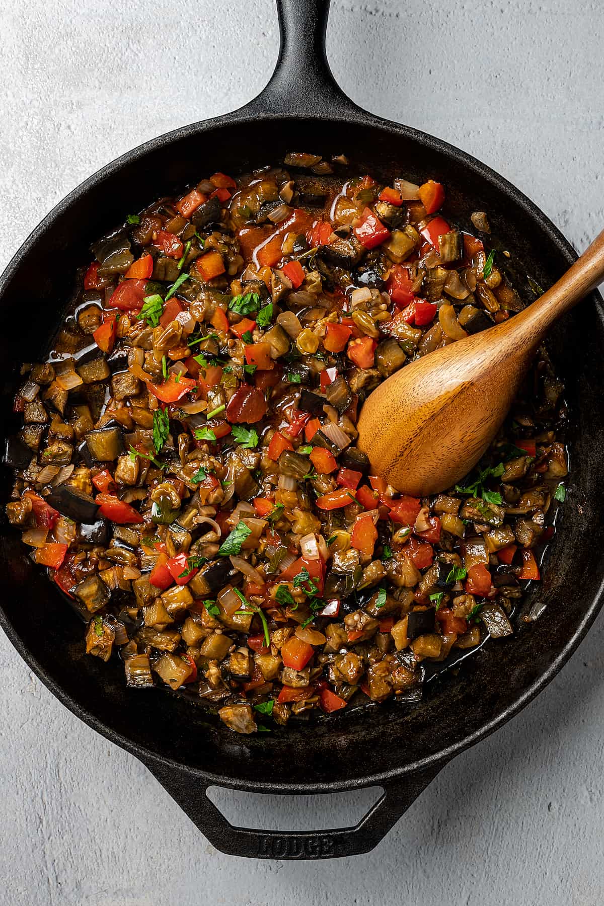Caponata cooking in a cast-iron skillet.