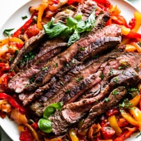 slices of grilled flank steak served over a bed of peperonata.