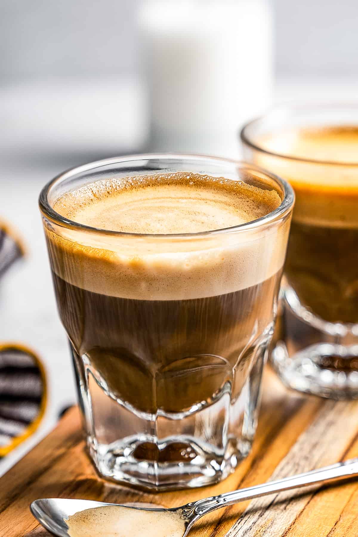 Side shot of two coffee glass mugs filled with cortado coffee.